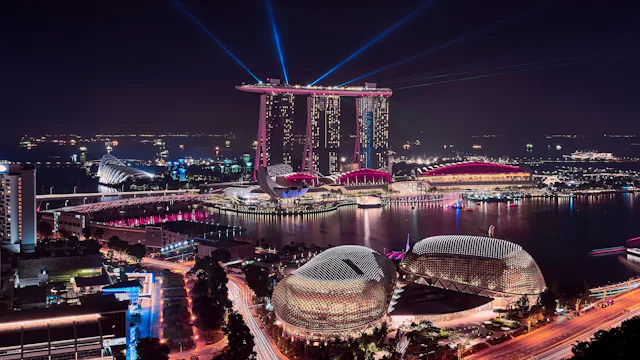 Singaporen kaupunki yöllä valaistuna.